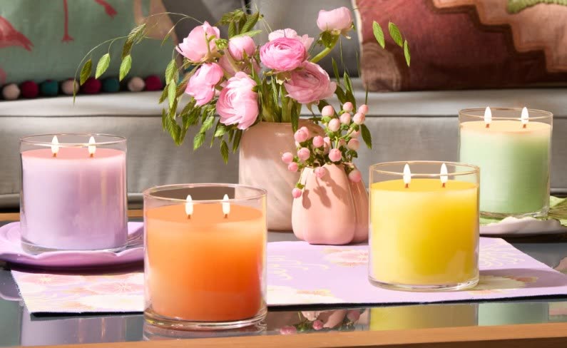 Bougies PartyLite à trois mèches et bouquet de renoncules roses